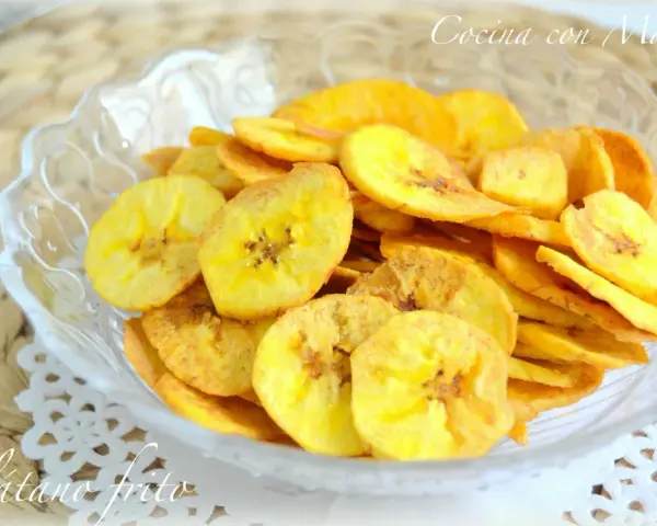 Crujientes rodajas de plátano frito en un cuenco de cristal. Un delicioso snack casero.