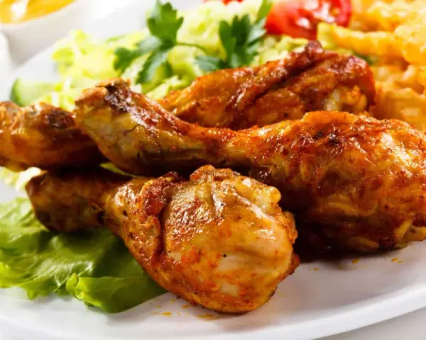 Crujientes muslos de pollo frito, acompañados de papas fritas, ensalada y tomate. ¡Un festín irresistible!