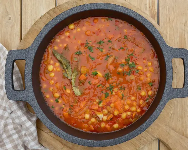 Guiso de garbanzos con verduras y laurel, listo para servir. Una deliciosa receta de garbanzos casera.