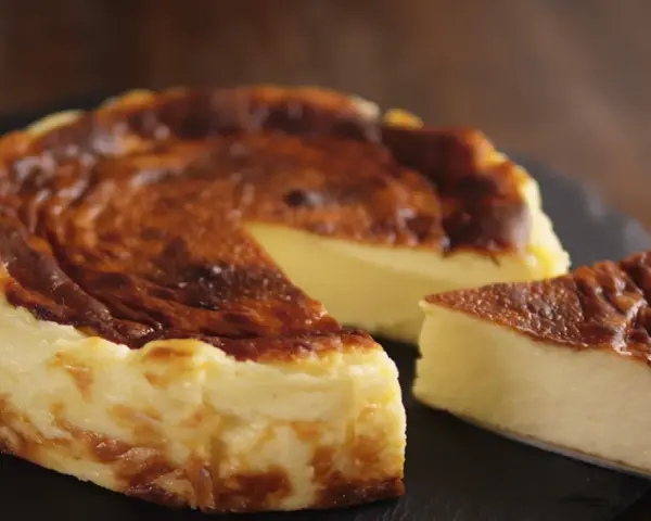 Tarta de queso al horno casera, dorada y cremosa, con una porción lista para disfrutar.
