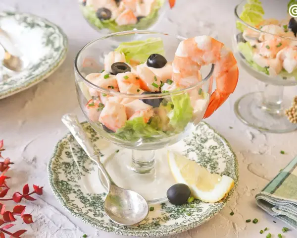 Delicioso cóctel de gambas servido en copa, con lechuga, aceitunas y un toque de limón. ¡Un clásico refrescante!