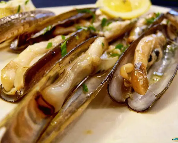 Navajas cocinadas en su jugo, con perejil picado y una rodaja de limón. ¡Estas navajas se pueden congelar para disfrutarlas más tarde!