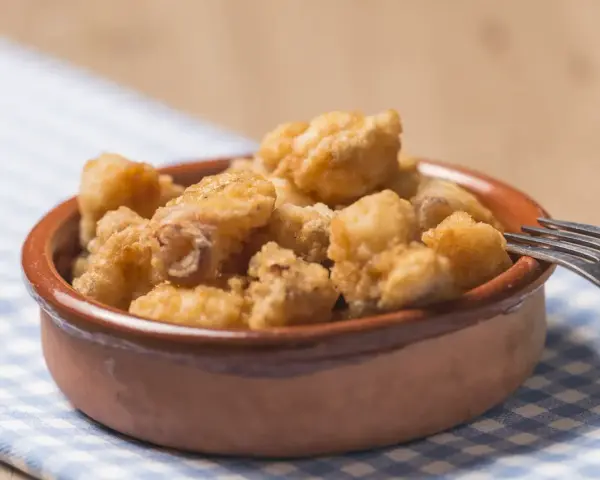 Tazón de fritura de pescado crujiente, listo para disfrutar con un tenedor.