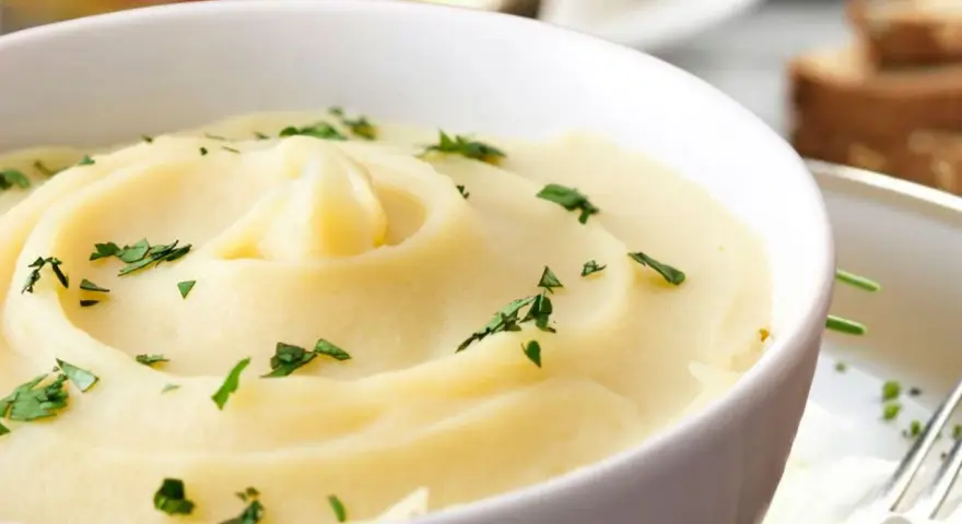 Cremoso parmentier de patata, adornado con perejil fresco, listo para ser disfrutado.