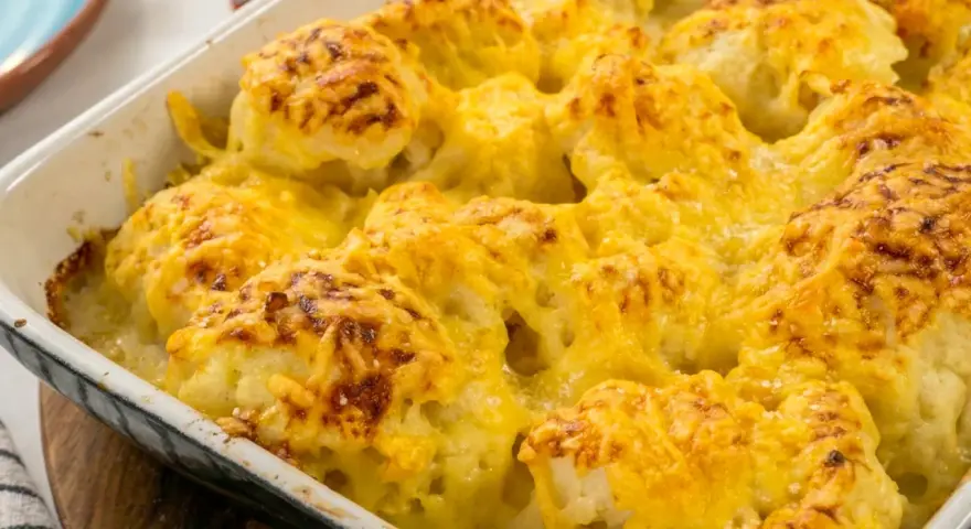 Coliflor gratinada con bechamel cremosa y queso dorado, lista para servir.