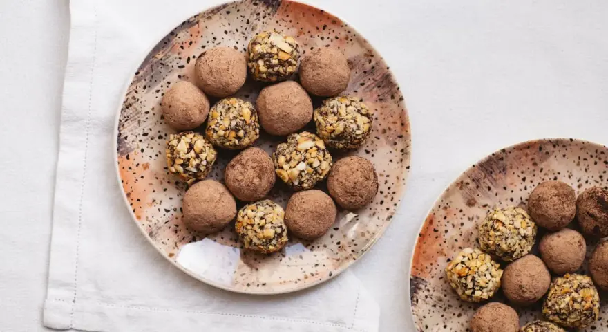 Dos platos con trufas de chocolate, algunas cubiertas de cacao y otras con trocitos de frutos secos. ¡Un placer para la vista y el paladar!