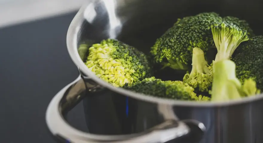 Brócoli fresco en una olla metálica, listo para cocción. El tiempo cocción brócoli olla normal es clave para su punto perfecto.