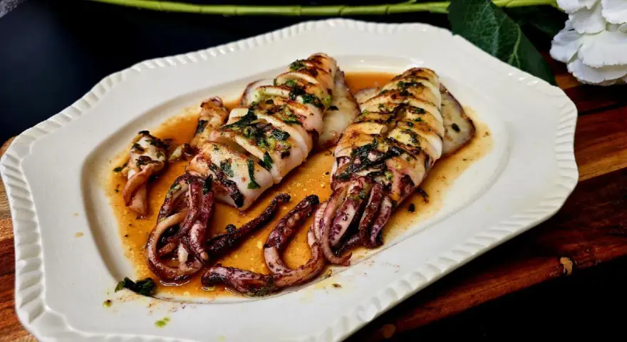 Calamar a la plancha, jugoso y tierno, bañado en una salsa dorada con hierbas. ¡Perfecto para aprender como hacer calamar a la plancha!