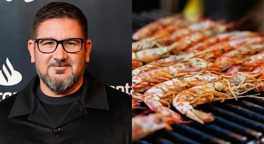 Hombre con gafas y barba junto a una parrilla llena de cigalas a la plancha, listas para ser degustadas.