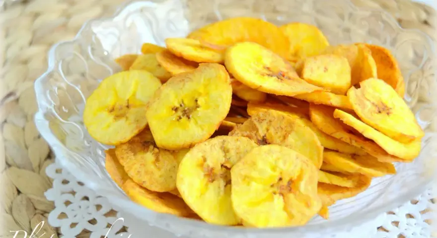 Crujientes rodajas de plátano frito en un cuenco de cristal. Un delicioso snack casero.