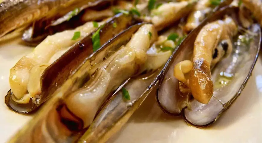 Navajas cocinadas en su jugo, con perejil picado y una rodaja de limón. ¡Estas navajas se pueden congelar para disfrutarlas más tarde!