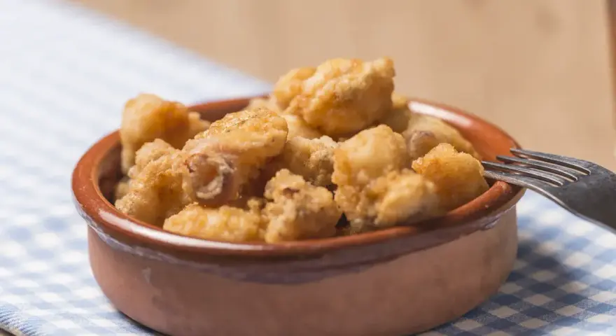 Tazón de fritura de pescado crujiente, listo para disfrutar con un tenedor.