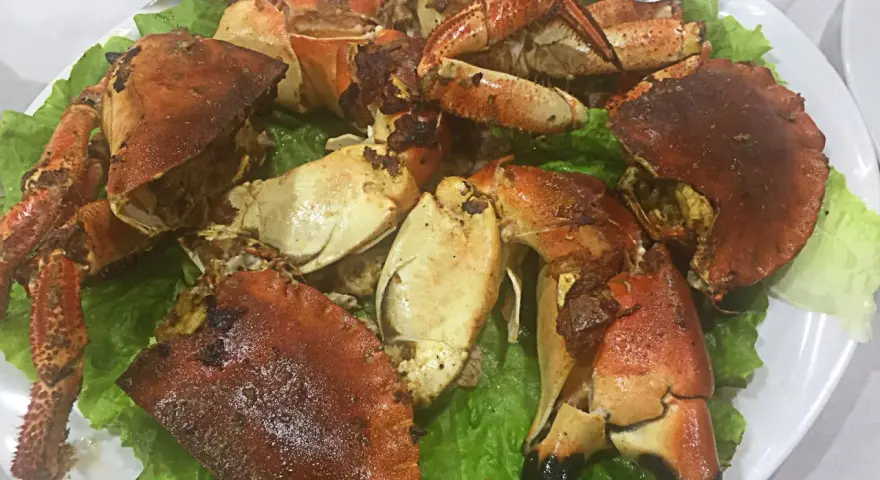 Buey de mar a la plancha servido sobre lechuga fresca. Un plato delicioso y listo para disfrutar.