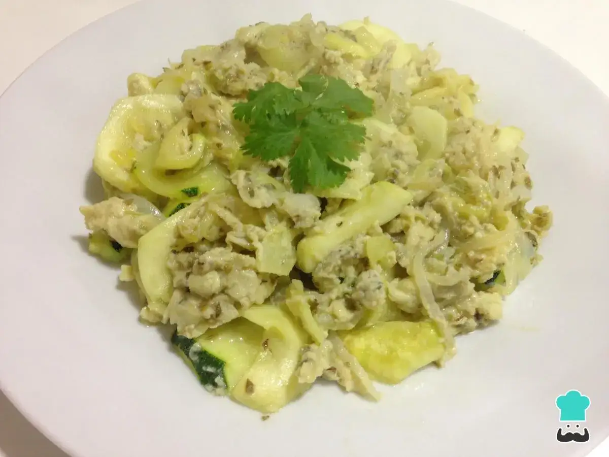 Delicioso revuelto de calabac&iacute;n con huevo y especias, adornado con una ramita de cilantro fresco.