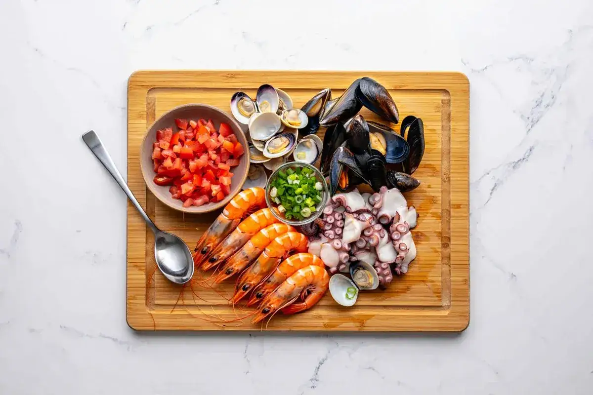 Ingredientes frescos para un delicioso salpic&oacute;n de marisco: gambas, pulpo, mejillones, almejas, tomate picado y cebolleta.