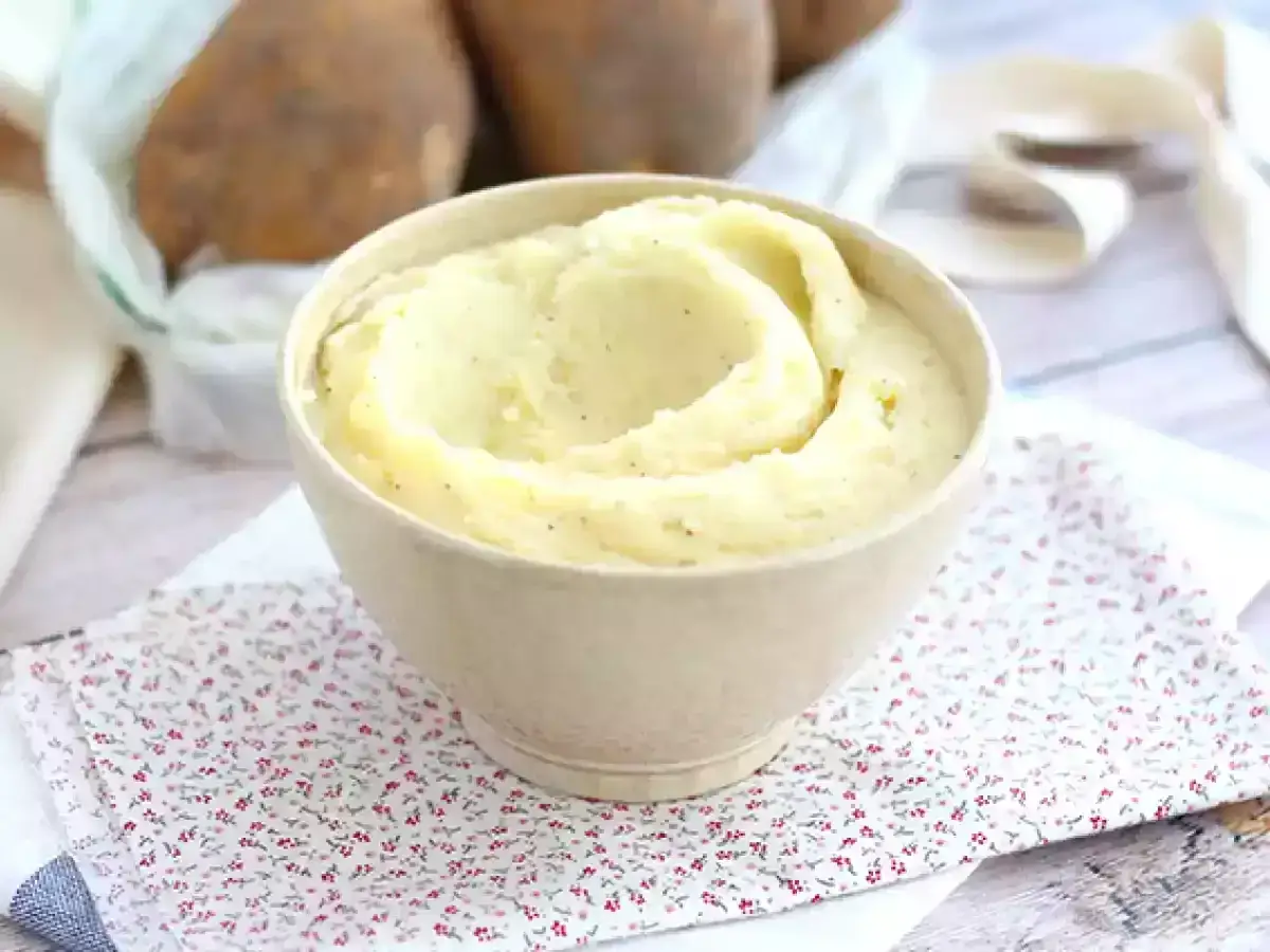 Un cremoso parmentier de patata, listo para servir. Patatas enteras al fondo.