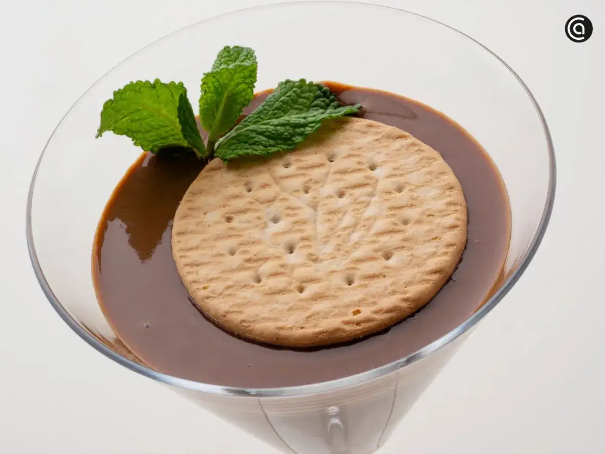 Deliciosas natillas caseras de chocolate, coronadas con una galleta y hojas de menta fresca.