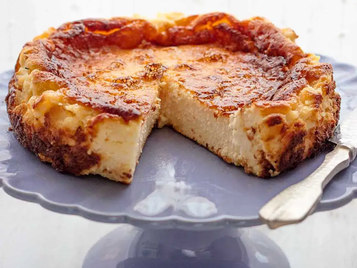 Tarta de queso casera, dorada y cremosa, servida en un plato morado. &iexcl;Perfecta para disfrutar!