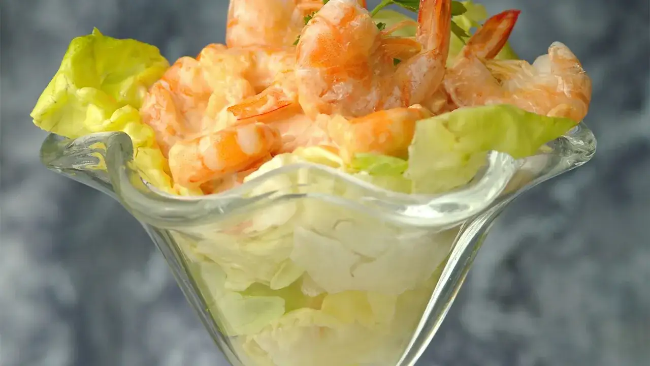 Delicioso c&oacute;ctel de gambas servido en copa de cristal con lechuga fresca.