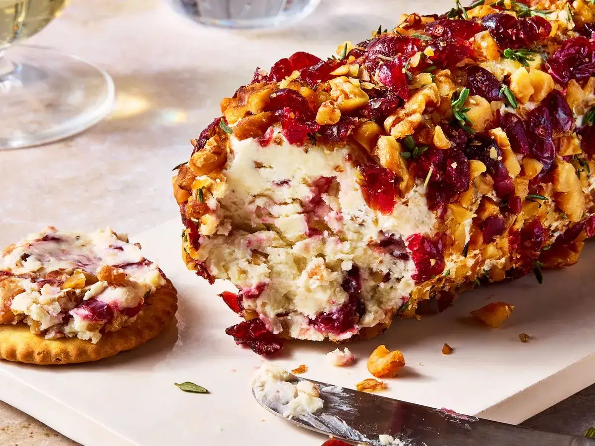 Queso cremoso cubierto de ar&aacute;ndanos y nueces, perfecto para aperitivos navide&ntilde;os originales. Una galleta untada espera.