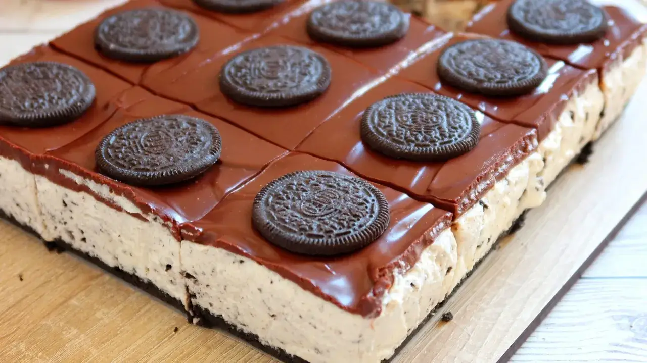 Deliciosa tarta de oreo, con capa cremosa y cobertura de chocolate brillante, decorada con galletas enteras.