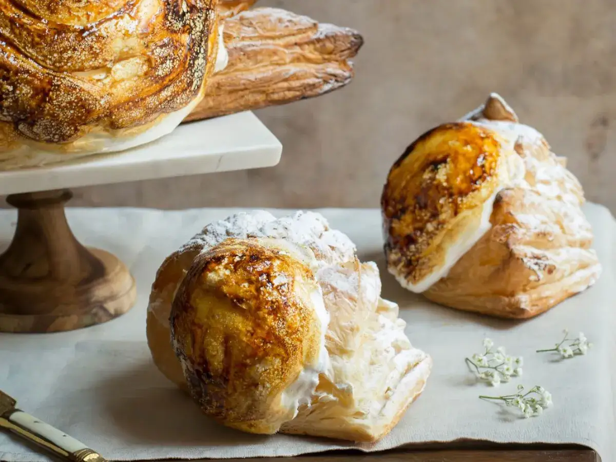 Delicioso pan de calatrava con merengue tostado y az&uacute;car glas, acompa&ntilde;ado de delicadas flores blancas.