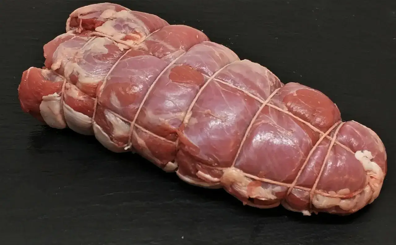 Un trozo de carne cruda, atado con hilo, listo para ser un delicioso roast beef.