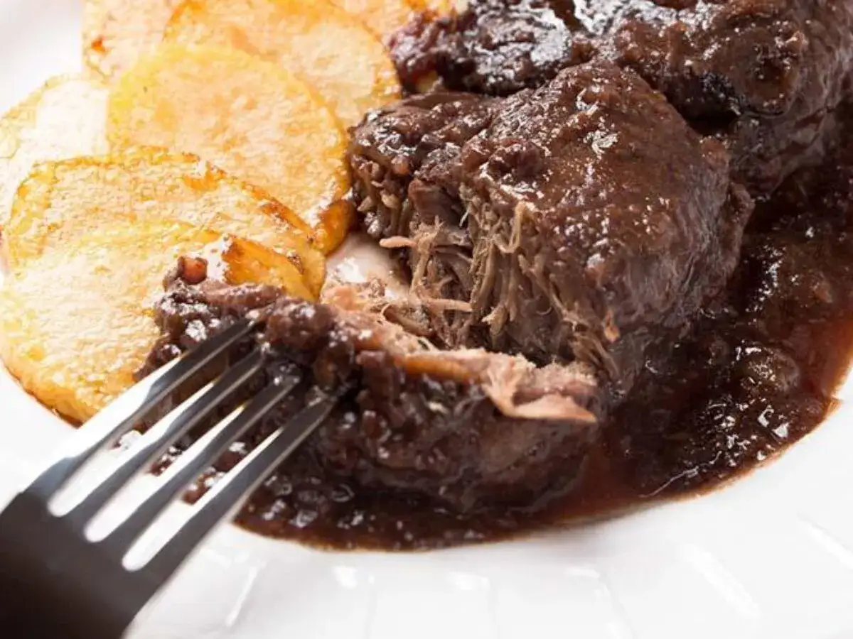 Carrilleras al vino tinto tiernas y jugosas, servidas con patatas doradas. Un plato reconfortante.