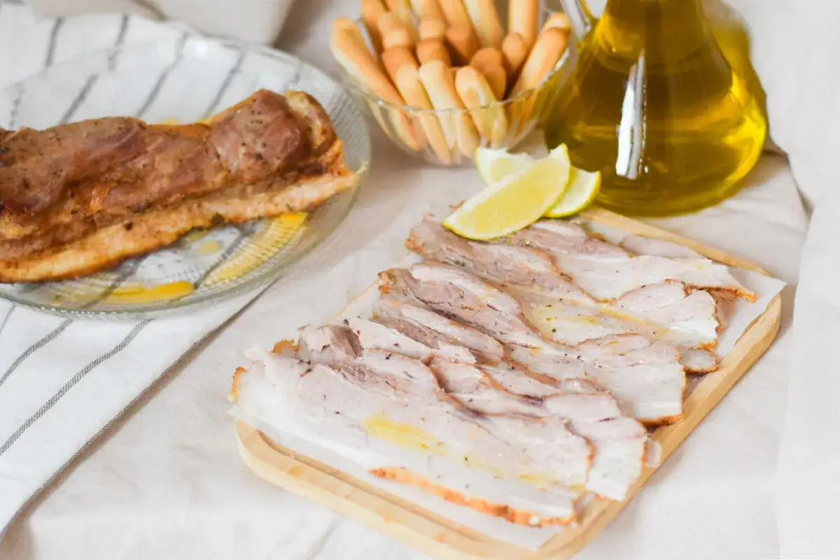Chicharrón de Cádiz, crujiente y jugoso, servido con limones y palitos de pan.