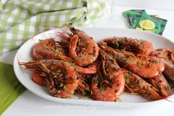 Plato de gambones al ajillo, jugosos y con perejil picado, listos para disfrutar.