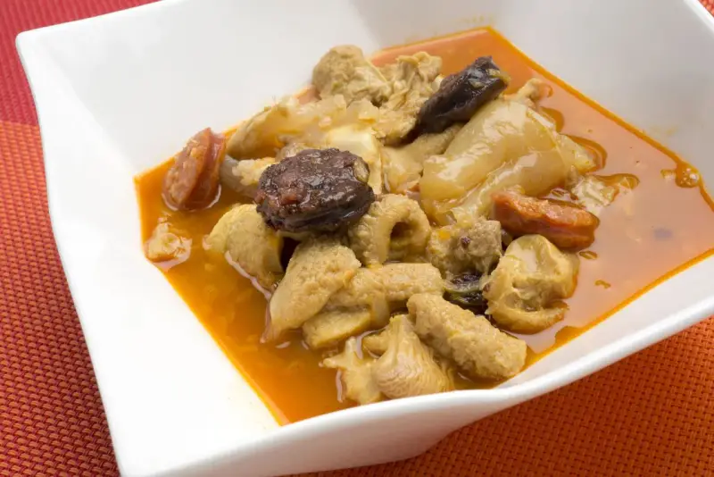 Un plato humeante de callos a la madrileña, con trozos de chorizo y morcilla en una rica salsa.